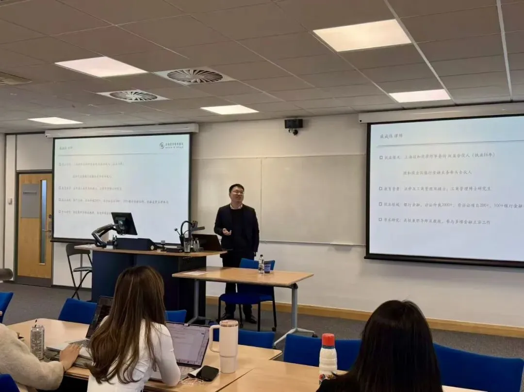 Chengwei Qi of Duan & Duan speaking to students in a seminar room at the University of Leeds, with slides on two screens